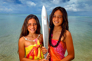 Eriteana and Natalia. In Rarotonga, Sisters Eriteana, 10 and Natalia, 11 stand with the baton in the local lagoon.